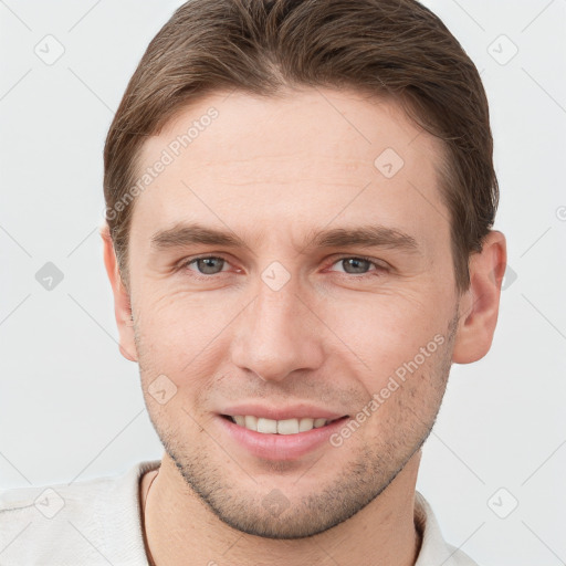 Joyful white young-adult male with short  brown hair and grey eyes