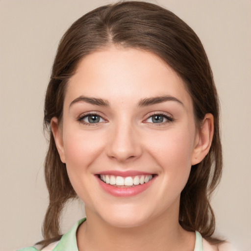 Joyful white young-adult female with medium  brown hair and green eyes