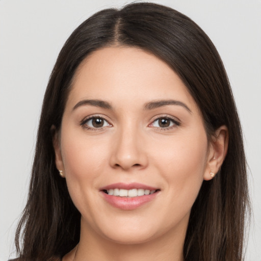 Joyful white young-adult female with long  brown hair and brown eyes