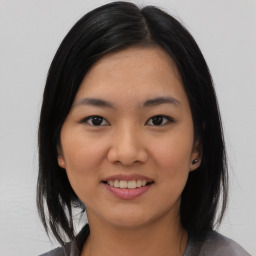 Joyful asian young-adult female with medium  black hair and brown eyes