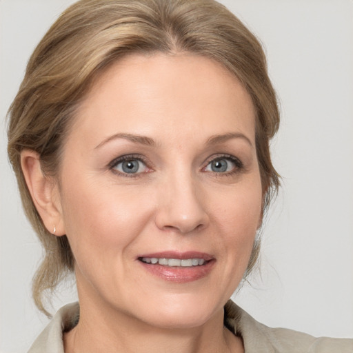 Joyful white adult female with medium  brown hair and grey eyes