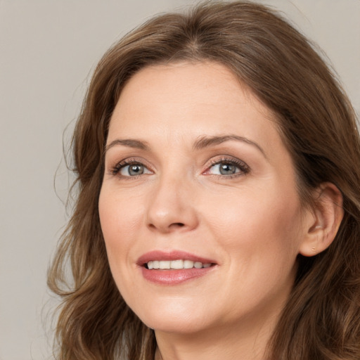 Joyful white adult female with long  brown hair and green eyes