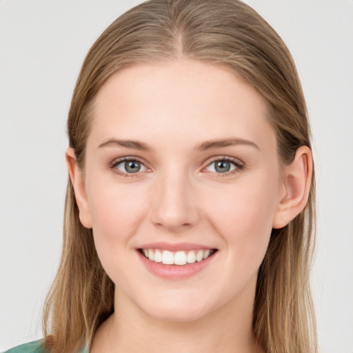 Joyful white young-adult female with long  brown hair and blue eyes