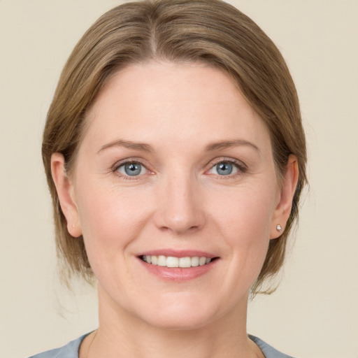 Joyful white young-adult female with medium  brown hair and blue eyes