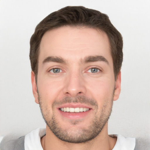 Joyful white young-adult male with short  brown hair and grey eyes