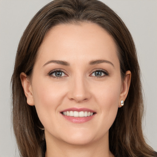 Joyful white young-adult female with long  brown hair and brown eyes