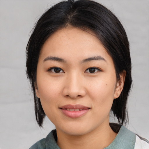 Joyful asian young-adult female with medium  black hair and brown eyes