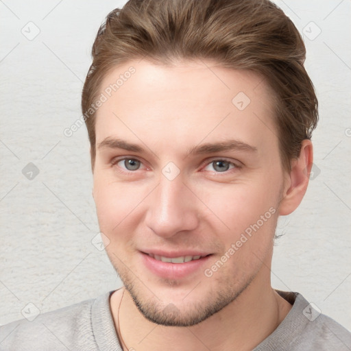 Joyful white young-adult male with short  brown hair and grey eyes