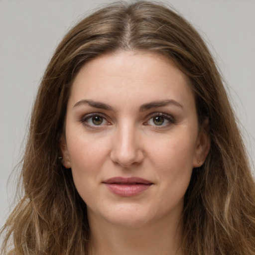 Joyful white young-adult female with long  brown hair and green eyes