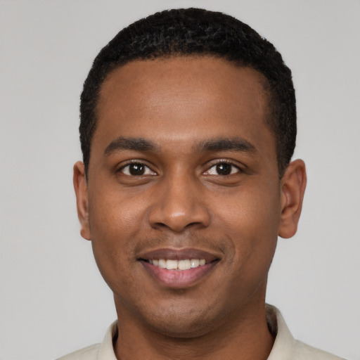 Joyful black young-adult male with short  black hair and brown eyes