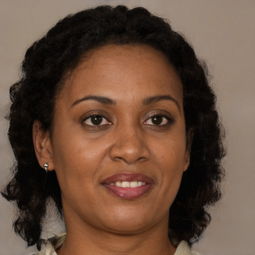Joyful black adult female with medium  brown hair and brown eyes