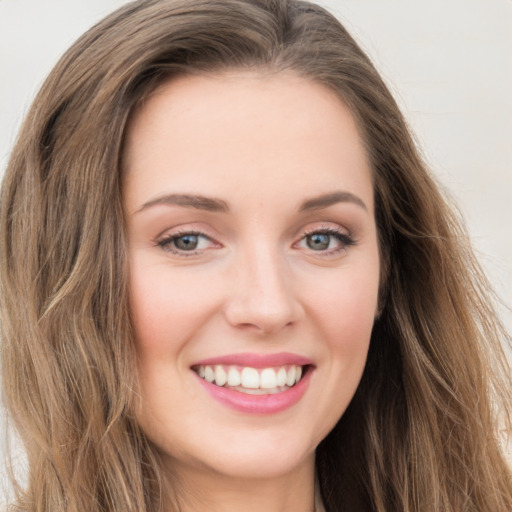 Joyful white young-adult female with long  brown hair and green eyes