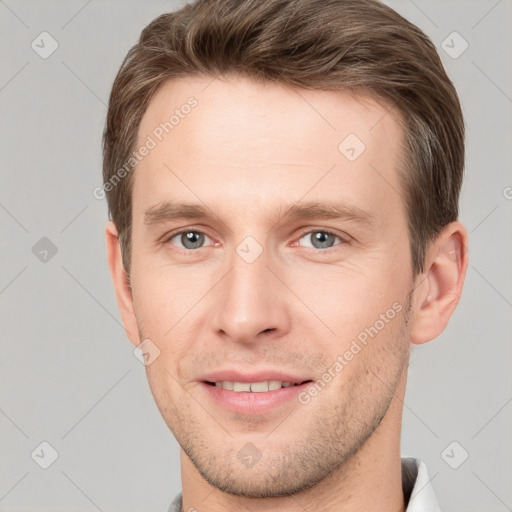 Joyful white young-adult male with short  brown hair and grey eyes