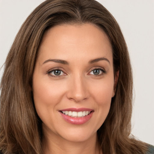 Joyful white young-adult female with long  brown hair and brown eyes