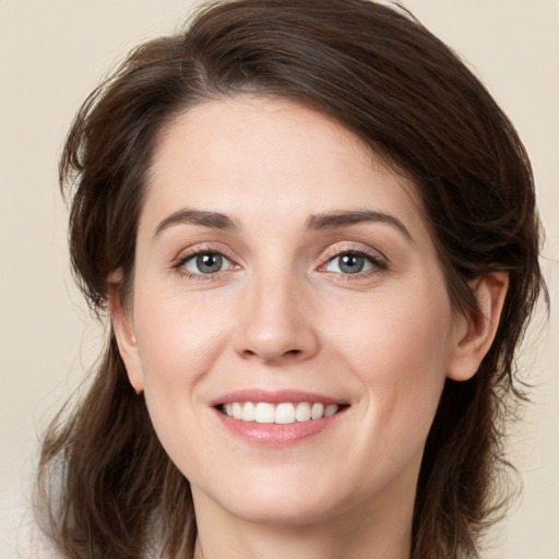 Joyful white young-adult female with medium  brown hair and green eyes