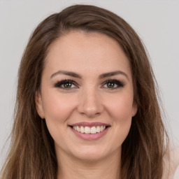 Joyful white young-adult female with long  brown hair and green eyes