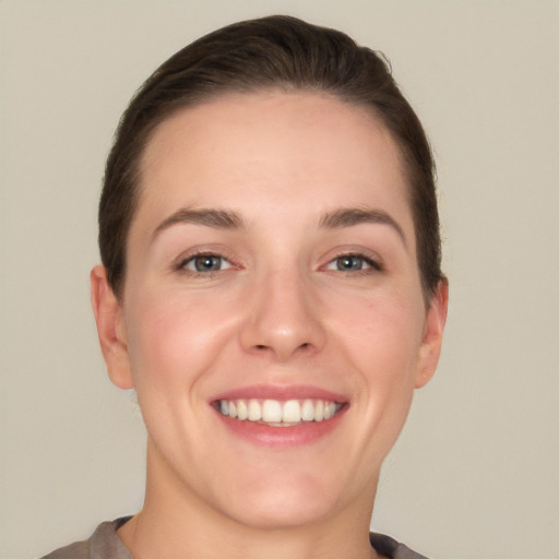 Joyful white young-adult female with short  brown hair and grey eyes