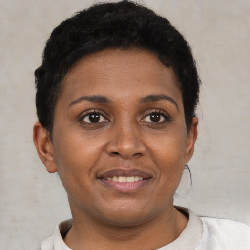 Joyful black young-adult female with short  brown hair and brown eyes