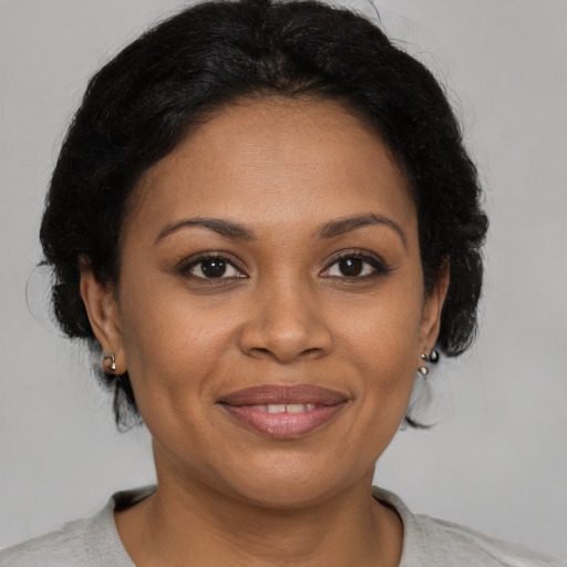 Joyful black young-adult female with short  brown hair and brown eyes