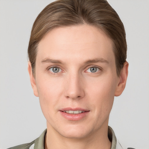 Joyful white young-adult male with short  brown hair and grey eyes