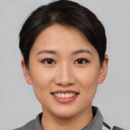 Joyful asian young-adult female with short  brown hair and brown eyes