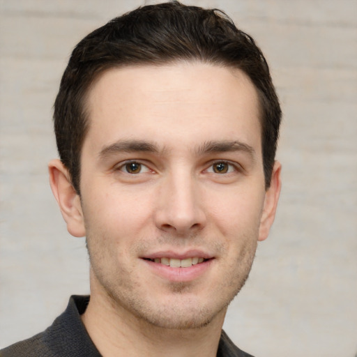 Joyful white young-adult male with short  brown hair and grey eyes