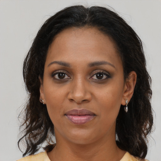 Joyful black adult female with medium  brown hair and brown eyes