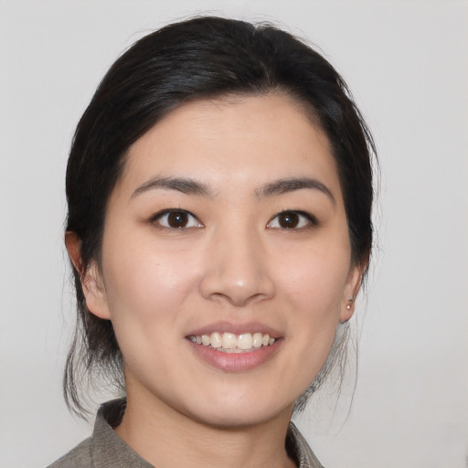 Joyful asian young-adult female with medium  black hair and brown eyes