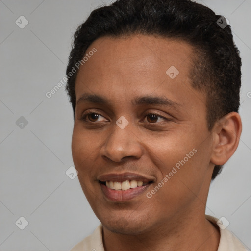 Joyful latino young-adult male with short  brown hair and brown eyes