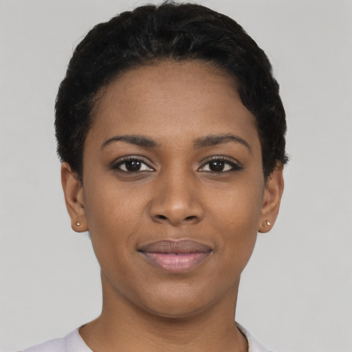 Joyful black young-adult female with short  black hair and brown eyes