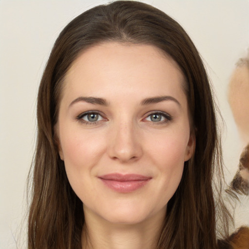 Joyful white young-adult female with long  brown hair and brown eyes