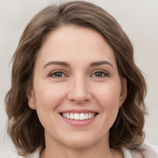 Joyful white young-adult female with medium  brown hair and grey eyes