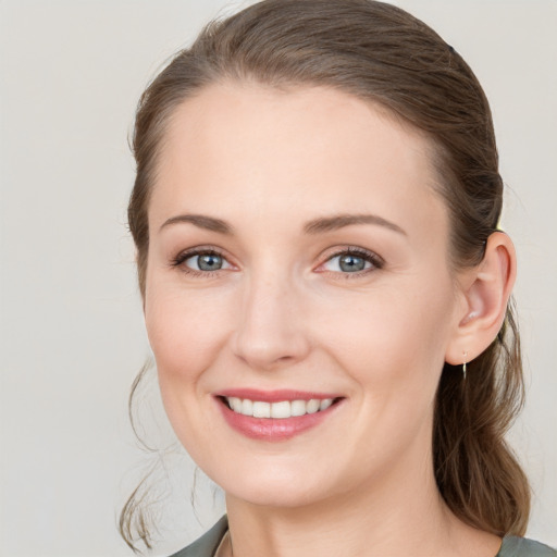 Joyful white young-adult female with medium  brown hair and grey eyes