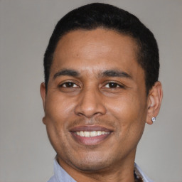 Joyful latino young-adult male with short  black hair and brown eyes