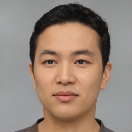 Joyful asian young-adult male with short  black hair and brown eyes