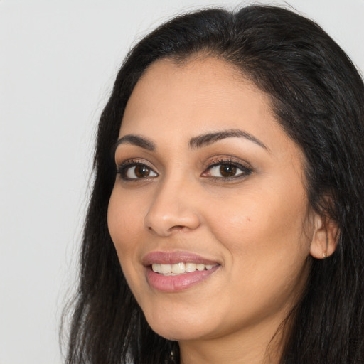 Joyful latino young-adult female with long  black hair and brown eyes