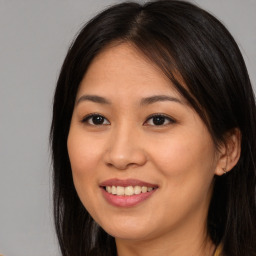 Joyful asian young-adult female with long  brown hair and brown eyes