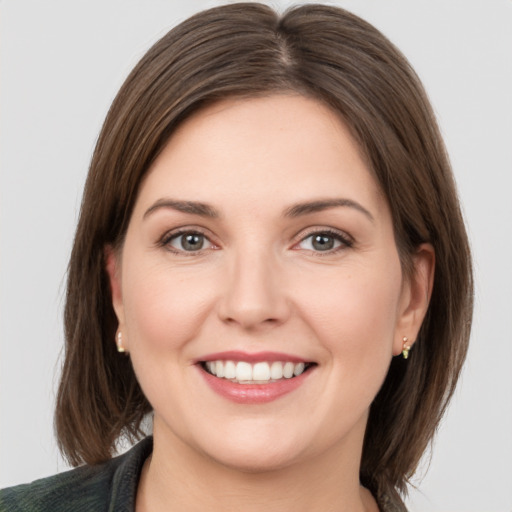 Joyful white young-adult female with medium  brown hair and grey eyes