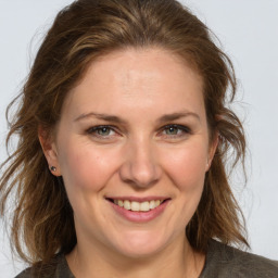 Joyful white adult female with medium  brown hair and grey eyes