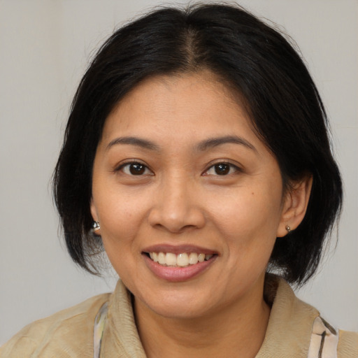 Joyful latino adult female with medium  brown hair and brown eyes