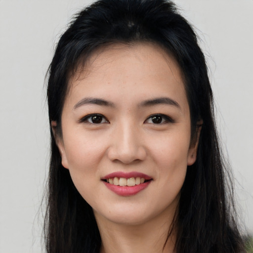 Joyful asian young-adult female with long  black hair and brown eyes