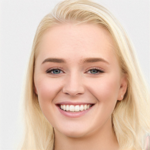 Joyful white young-adult female with long  brown hair and blue eyes