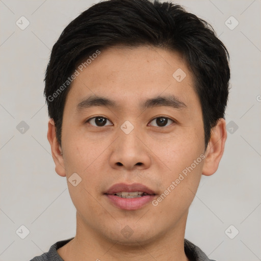 Joyful asian young-adult male with short  black hair and brown eyes