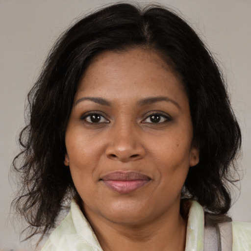 Joyful black adult female with medium  brown hair and brown eyes
