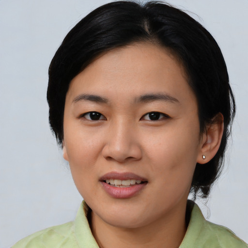 Joyful asian young-adult female with short  black hair and brown eyes