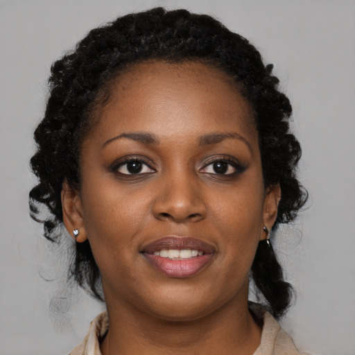 Joyful black young-adult female with medium  black hair and brown eyes
