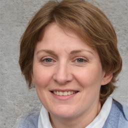 Joyful white adult female with medium  brown hair and blue eyes