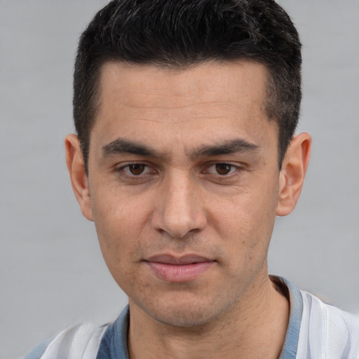 Joyful white young-adult male with short  black hair and brown eyes
