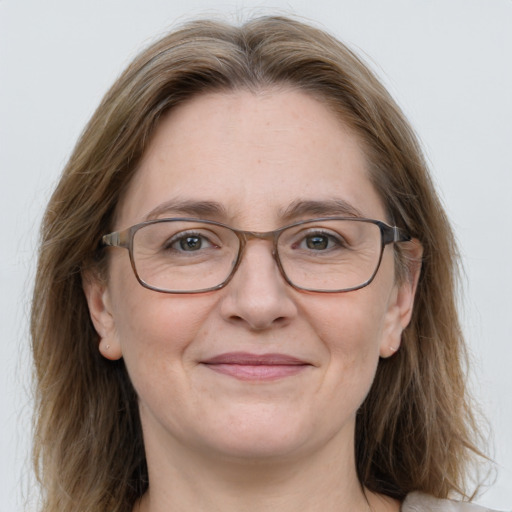 Joyful white adult female with medium  brown hair and blue eyes