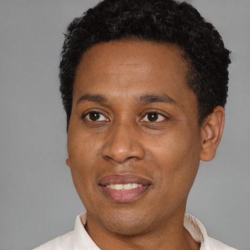 Joyful black adult male with short  brown hair and brown eyes